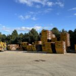 Skips piled up against trees and blue sky